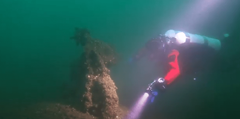 diver with flashlight on kingston shipwreck