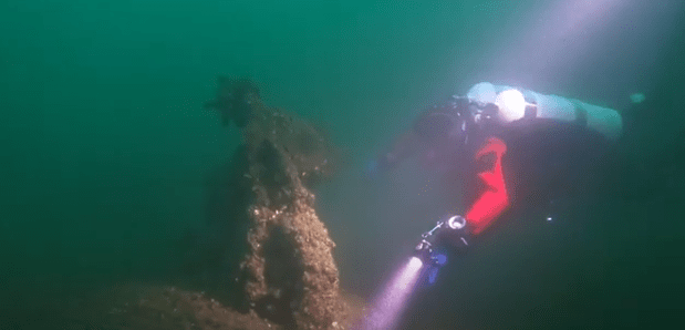 diver with flashlight on kingston shipwreck